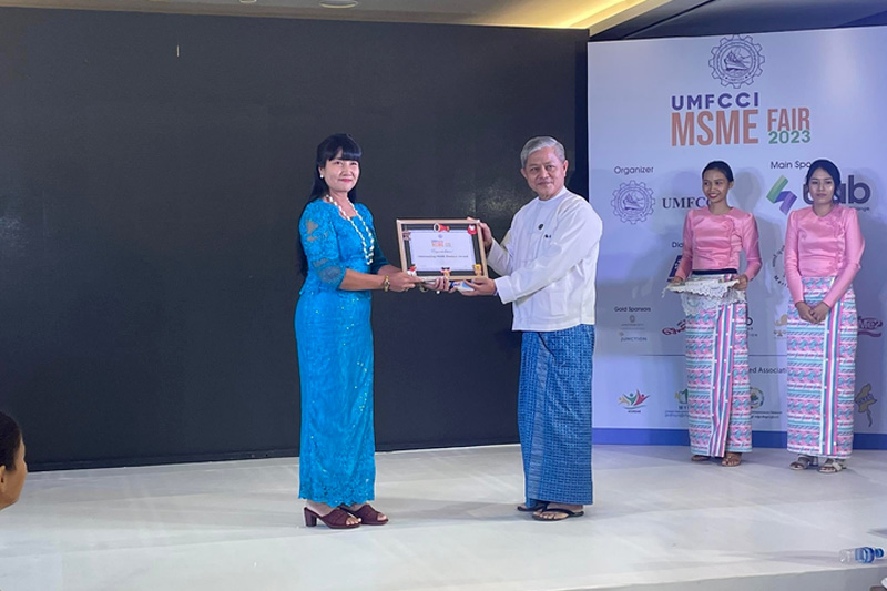 Hein Shwe Yaung Co owner Daw Hay Mar San accepts her outstanding MSME product award.