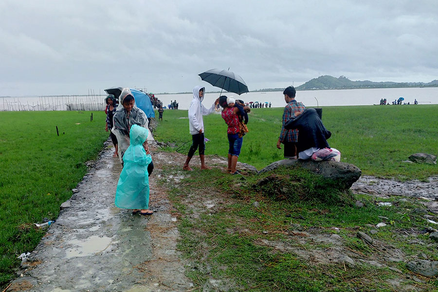 မိုးရေထဲတွင် ထွက်ပြေးတိမ်းရှောင်နေကြသည့် ရခိုင်ဒေသခံများ။ ဓာတ်ပုံ - ကိုထွန်းခိုင်