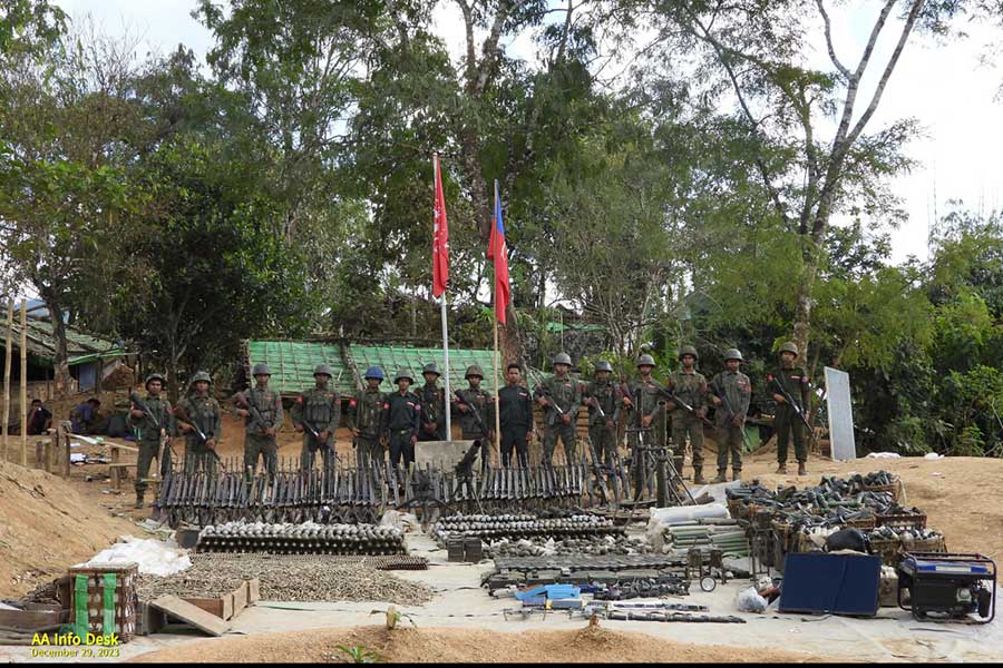 Arakan Army (AA) members with seized weapons from the Khawe tactical command base.