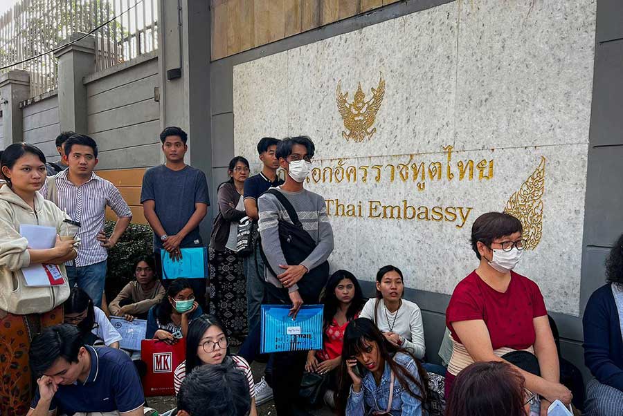Visa applicants wait outside the Thai Embassy in Yangon. (Photo: AFP)