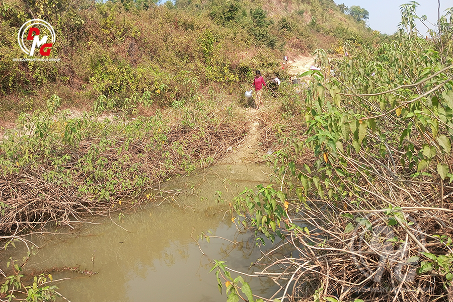 ကားလမ်းဘေးရှိ ရေမြောင်းမှရေကို ခပ်ယူသုံးစွဲနေရသော ပုဏ္ဏားကျွန်းမြို့နယ်မှ စစ်ဘေးရှောင်အမျိုးသမီးတစ်ဦးကို ယခုနှစ် ဇန်နဝါရီလအတွင်းက တွေ့ရစဉ်။
